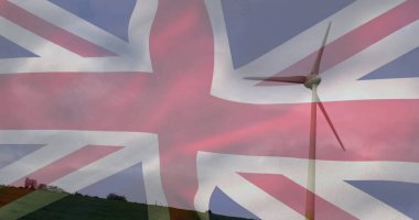 Çimenli yamaçta dönen beyaz rüzgar türbini, Union Jack bayrağı örtülmüş, kopyalama alanı. Yenilenebilir, sürdürülebilirlik, çevre dostu, kırsal alan, vatanseverlik, yenilikçi