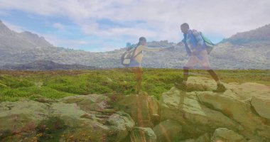 Sırt çantaları, botları ve kayalık yamaçlara tırmanırken kadın yürüyüşçünün elini tutuyor. Macera, keşif, açık hava, takım çalışması, esneklik, dağ, manzara