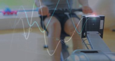 Dijital ekran kaplamalarıyla fitness salonunda kürek çeken formda bir adam gidonu çekiyor. Egzersiz, güç, atletizm, eğitim, kardiyo, sağlık, motivasyon