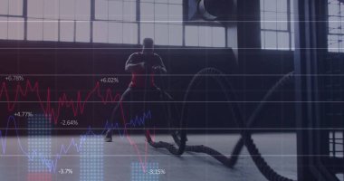 Spor salonunda kırmızı gömlekli, savaş halatları tutan, çizgi çizgileri olan bir antrenör. Fitness, strength, training, industrial, modern, sebat, health