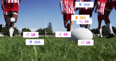 Kırmızı ve beyaz formalı koşu takımı ön planda beyaz topla ragbi sahasında koşuyor. Atletizm, takım çalışması, rekabet, atletizm, açık hava, sportmenlik, canlılık