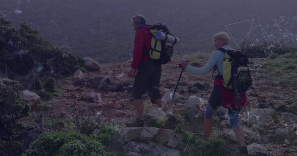 Hiking seniors in trekking gear navigating rocky mountain trail, with trekking poles and backpacks. Outdoor, adventure, exploration, rugged, fitness, nature, wilderness