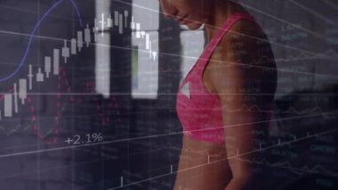 Bir kadın spor salonuna bakıyor, finansal tabloları izliyor ve pazı kıvırcıklarıyla güç kazanıyor. Zindelik, güç, kararlılık, başarı, odaklanma, modern, enerjik