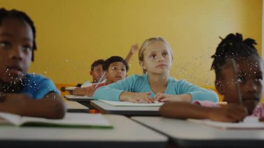 Sınıfta oturan beş öğrenci kalem tutuyor, öğretmenler soru sorduktan sonra el kaldırıyor. Eğitim, öğrenim, sınıf, çocuklar, kırtasiye, akademik, dikkat