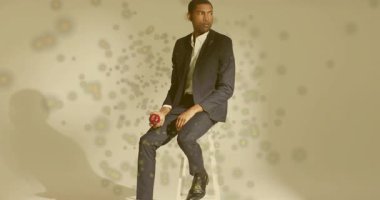 Adam kırmızı elmayı tabureden dönen dijital parçacıklara fırlatıp teknoloji tanıtımı için yakalıyor. Gelecekçi, yenilikçi, soyut, minimalist, düşünceli, dijital sanat, zarafet