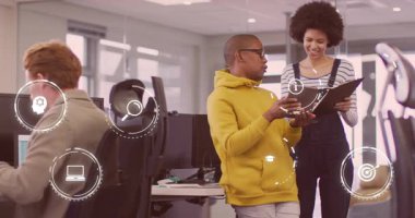 İşyerindeki kadına yaklaşan adam, klasörü bilgi simgeleri çerçevesi tartışması olarak açıklıyor. İşbirliği, takım çalışması, şirket, üretkenlik, modern, yenilik, dijital