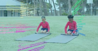 Çimenli tarlada diz çöküp siyah paspaslara uzanan iki çocuk, spor yapmak için pürüzsüz kırışıklıklar yaratıyor. Açık hava, etkinlik, arkadaşlık, takım çalışması, spor, egzersiz, gündelik