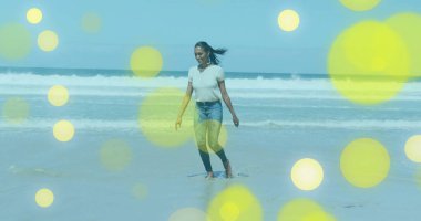 Beyaz bluz giyen ve kot pantolonlu bir kadın sahilde sığ sularda yürüyordu. Macera, sükunet, rahatlık, gündelik, doğal, sükunet, tasasız