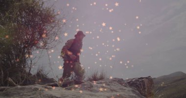 Sırt çantalı, kayalık yamaçta geniş kenarlı şapka ve açık hava yeleği giyen yalnız yetişkin bir erkek. Macera, keşif, vahşi doğa, açık hava, engebeli doğa, yolculuk