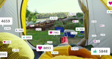 Karavanın kırmızı çoraplı ayakları göl kenarında açılan çadıra doğru uzanıyor, sosyal simgelerle. Macera, açık hava, eğlence, doğa, rahatlama, kamp, manzara