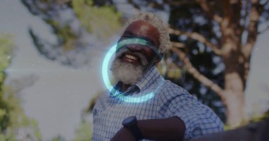 Ağaç korkuluklara yaslanmış, kareli gömlek ve kol saatiyle gülümseyen son sınıf öğrencisi. Yaşlılar, açık hava, doğa, yaşam tarzı, rahat, canlı, sağlıklı.