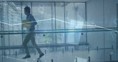 Sarı klasörle yürüyen maskeli Çinli adam cam korkulukların, veri tablosunun ve kopyalama alanının önünden geçiyor. Profesyonel, kurumsal, modern, gösterişli, veri, finansal, kentsel