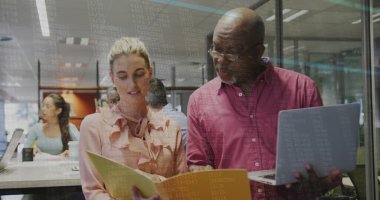 Kestane rengi gömlekli son sınıf öğrencisi ve ofis odasında dosyasına bakan şeftali rengi bluzlu bir kadın. Takım çalışması, yenilik, profesyonellik, çalışma alanı, modern, sınıf, iletişim