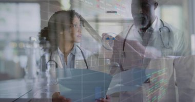 Klinikteki hasta dosyalarını inceleyen beyaz önlüklü doktorlar, stetoskoplar, holografik çizelgeler. Tıbbi, sağlık, teknoloji, profesyonel, yenilik, işbirliği, tanı