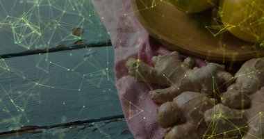 Ginger köklerini pembe bezin üzerinde sergiliyor. Dısal ağ kaplamalı, mavi tahta tahtaların üzerinde. Bitkiler, organik, kırsal, tıbbi, sağlık, aşçılık, teknoloji