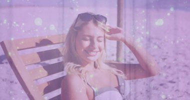 Kumlu sahildeki tahta şezlongda, mayo ve güneş gözlükleriyle rahatlayan bir kadın. Sahil, yaz, sükunet, tatil, açık hava, yaşam tarzı.