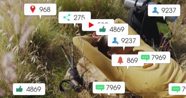 Sırt çantası ve yürüyüş direkleri ile uzun otların üzerinde yüzen bildirim simgelerini izleyen yaslanmış bir kadın. Macera, farkındalık, açık hava, keşif, modern, huzur, rahatlık.