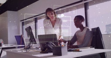 İş kıyafetleri giymiş, dizüstü bilgisayara bakan ve ofiste belgelerle yazan kadınlar. İşbirliği, takım çalışması, şirket, modern, üretkenlik, çalışma istasyonu, profesyonel