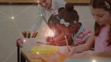 Öğretmen, öğrencileri kurşun kalemle yazmaya yönlendiriyor. Yazma alıştırması yapan çocukları kameraya alıyor. Sınıf, eğitim, öğrenim, akıl hocalığı, okur yazarlık, öğretici, akademik