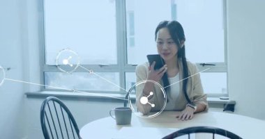 Çinli bir kadın akıllı telefondan ses girişi başlatırken simgeler teknoloji ağı oluşturuyor. Teknoloji, iletişim, bağlantı, veri, dijital, yenilik, kablosuz