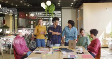 Pazarlama ekibi masada toplanıyor, metrik simgeler yukarıda dönüyor ve harekete geçiyor. İşbirliği, takım çalışması, yenilik, dijital, analitik, beyin fırtınası, profesyonel