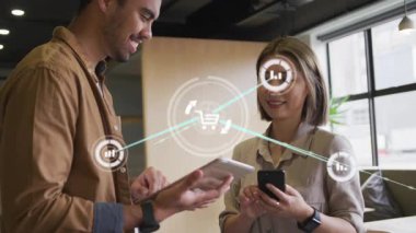 Tablet dinleyen bir adam ve iş tanıtımı sırasında el arabası simgesi ve çizelge ağını gösteren bir kadın. İşbirliği, ağ oluşturma, teknoloji, yenilik, iş dünyası, modernite, takım çalışması