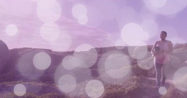 Spor meraklısı kıyı yolunda koşuyor, duruyor, denizi inceliyor, su şişesinden içiyor. Macera, sağlık, doğa, manzara, aktif giysi, açık hava, keşif