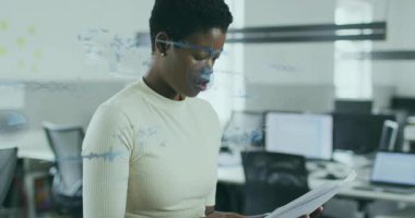 Teknoloji ofisinde evrakları tarayan bir kadın, analiz için mavi veri görsellerinin geçmesine neden oluyor. Teknoloji, yenilik, analitik, veri, çalışma alanı, profesyonel, modern