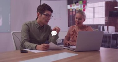 Ofis ikilisi dizüstü bilgisayarla raporu tartışıyor ve yazılı sayfaları sohbet baloncukları yükseldikçe işaret ediyor. İşbirliği, takım çalışması, iletişim, beyin fırtınası, modern, profesyonel, üretkenlik