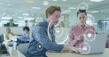 İş ofisinde çalışan erkek ve kadın, Stylus tap verilerini analiz eden simge paneli. İşbirliği, takım çalışması, dijital arayüz, veri analizi, modern çalışma alanı, profesyonel tartışma, yenilik