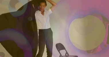 Sandalyedeki paltoya uzanan manken, teknik projeksiyonlar arasında stil yapmak ve çekim yapmak için dönüyor. Moda, podyum, zarafet, hareket, çağdaş, sanat, minimalizm