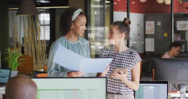 İş arkadaşları tableti inceliyor, planı gözden geçiriyor ve çizelgeleri plan üzerinde genişletiyor. İşbirliği, takım çalışması, analitik, dijital arayüz, akıllı çalışma alanı, profesyonel, modern tasarım