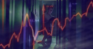 Teknisyen veri merkezinde diz çöküp tablet tarama ölçümlerini yükselterek kırmızı mavi finans grafiklerini gösteriyor. Teknoloji, analitik, veri, dijital, kurumsal, modern, yenilik