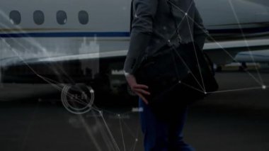 Özel jetin yanında yürüyen iş gezgini, havacılık verilerini gösteren ağ grafikleri başlatıyor. Lüks, profesyonellik, seyahat, şirket, ulaşım, yenilik, sofistike