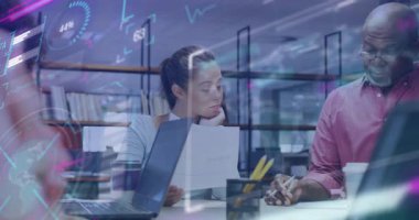 İş arkadaşları, cam duvardaki verilerle raporları tarıyor ve kararları yönlendiriyor. İşbirliği, takım çalışması, analitik, modernlik, iletişim, yenilik, strateji