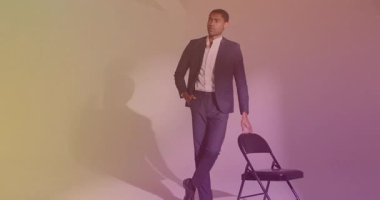 Sandalyeye yaslanan erkek manken jel ışıklarının arasında ceketini düzeltiyor. Profesyonel, moda, portre, stüdyo, zarif, çok yönlü, şık