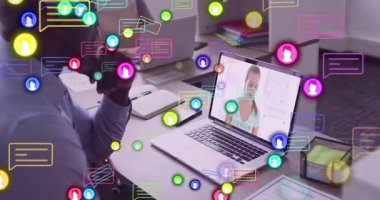 Adam dizüstü bilgisayarı açıyor ve ofiste iş görüşmesi yapıyor. Renkli mesaj simgeleri etrafta dolanıyor. İşbirliği, teknoloji, iletişim, takım çalışması, yenilik, modern, profesyonel