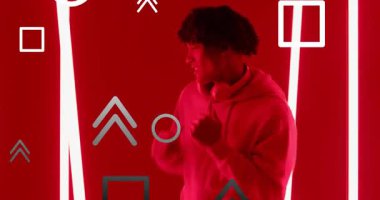 Müzik adamı tekmeliyor kulaklıkları ayarlıyor, kırmızı ışıklı neon tüplerin arasında dans ediyor, yüzen şekiller. Dinamik, fütüristik, gece hayatı, hareket, kentsel, canlı, enerjik