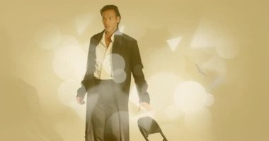 Model stüdyoya giriyor, ceketi ayarlıyor silueti mercek fişekleri ile göstermek için sallıyor. Şık, çağdaş, dramatik, minimalist, zarif, dinamik, canlı