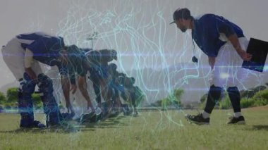 Elinde not panosu ve düdüğü olan koç beyzbol antrenmanında oyuncuları takip ediyor, duruşunu inceliyor. Atletizm, takım çalışması, antrenman, sportmenlik, açık hava, rekabet, disiplin