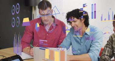 İki analist gümüş dizüstü bilgisayarı açıp animasyon çizelgelerine işaret ederek iş verilerini görselleştiriyor. İşbirliği, takım çalışması, analitik, veri görselleştirme, modern ofis, profesyonel, iş zekası