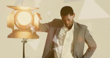 Spot ışığına dayanan model sürüklenen üçgenleri ve pürüzsüz giysiyi hazırlıyor. Minimalist, düşünceli, geometrik, profesyonel, sofistike, aydınlatma, soyut