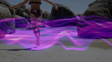 Kayalık Kum Koyu 'nda koşan bir çocuk teknoloji için mor dalga biçimini başlatıyor. Macera, keşif, açık hava, neşeli, canlı, dinamik, doğa