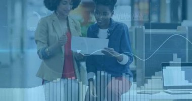 Ellerinde yazılı rapor tutan ve ofisteki mali verileri takip etmek için canlandırılmış dalga formlarını çalıştıran kadınlar. İşbirliği, takım çalışması, analitik, profesyonel, modern, çalışma alanı, bilgi