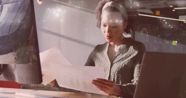 Veri analisti rapor sayfalarını çıkarıyor, çizelgeleri inceliyor ve dijital grafiklerle notlar yazıyor. Profesyonel, ofis, üretkenlik, modern, analiz, çalışma alanı, dijital