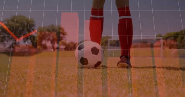 Ayakta duran sporcu kırmızı çorap giyiyor, futbol sahasında siyah kramponlar takıyor, kale direkleri ve veri örtüsü var. Spor, analitik, performans, açık hava, spor, rekabet, eğitim