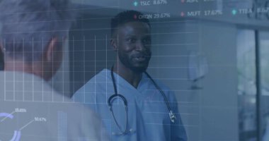 Hastane koridorunda steteskoplu önlük giymiş dijital çizelgeleri olan konuşan bir doktor. Tıbbi, sağlık, danışma, tanı, teknoloji, takım çalışması, profesyonel