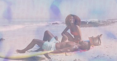 Sahilde kırmızı bikini ve şort giyen, sörf tahtası, plaj havlusu ve çanta taşıyan rahat bir çift. Sahil, eğlence, sahil, tatil, açık hava, yaşam tarzı, hayat dolu.