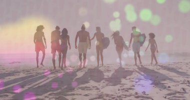 Gün batımında sahil şeridi boyunca sörf tahtası taşıyan sekiz yetişkin, pastel gökyüzü. Kıyı, macera, coşku, eğlence, yoldaşlık, günbatımı, yaşam tarzı