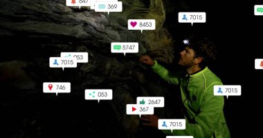 Neon yeşil ceketli ve farlı bir adam mağarayı keşfediyor, yüzen medya simgeleriyle, kopyalama uzayı. Macera, keşif, teknoloji, engebeli, açık hava, dijital, gece vakti